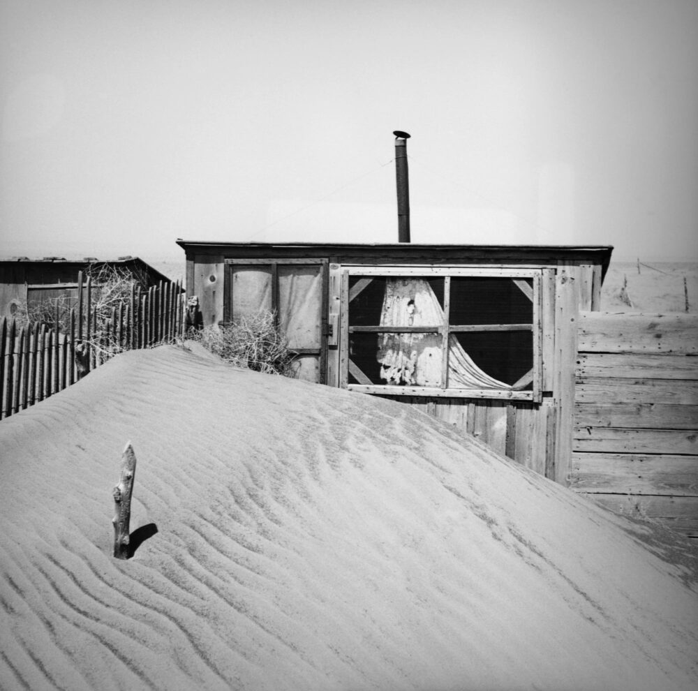 Dust bowl image of cabin and sand dune